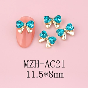 Detailed macro view of 11.5x8mm blue heart rhinestone bow nail charms with gold alloy base