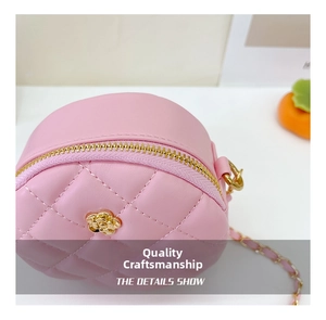 Detailed close-up of pink quilted round bag with gold petal buckle and metal zipper