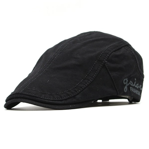 Detail of black cotton beret cap featuring side gsian FASHION embroidery and seam texture