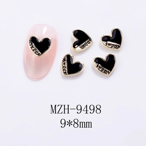 Detailed view of heart-shaped nail charms with gold edges and SWEET engraving