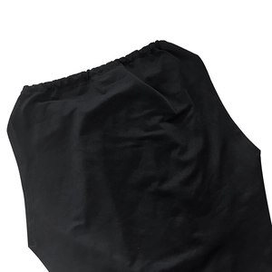 Detail shot of the elastic waistband and pleated black fabric texture on the dress