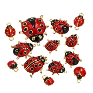 Red and black ladybug charms in various sizes with golden metal rings for DIY jewelry