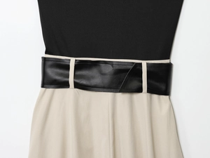 Détail de la taille bicolore avec une large ceinture en similicuir noir élégante