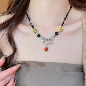 Detailed close-up of a handmade ethnic beaded necklace featuring a red ceramic heart pendant