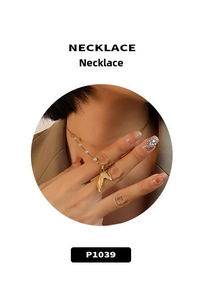 Detail view of a 18K gold plated fish tail necklace with white pearls on a thin chain