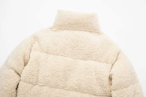 Gros plan sur la texture de la veste en polaire blanc crème et les détails du col