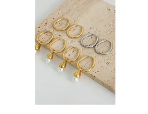 Detailed macro view of French vintage pearl earrings on a beige stone display tray