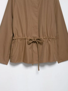Detail of khaki cropped jacket showing drawstring waist design and fabric texture