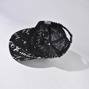 Black baseball cap featuring white graffiti print with adjustable metal buckle closure