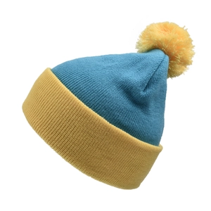 Close-up of blue and yellow knit hat texture with a soft ribbed pattern and fluffy pompom