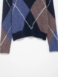 Close-up of the ribbed hem and cuffs on this classic navy argyle knit sweater