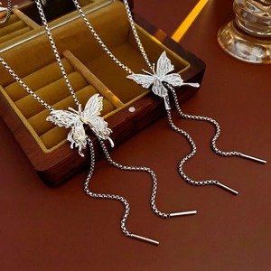 Silver butterfly pendant necklace with elegant long chain tassels on jewelry box
