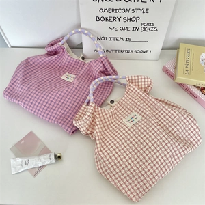 Dettaglio della borsa tote a scacchi con manici in corda colorata e chiusura a scatto