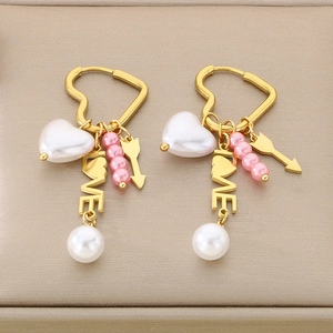 Golden heart earrings featuring pearl tassels and love charms on beige background