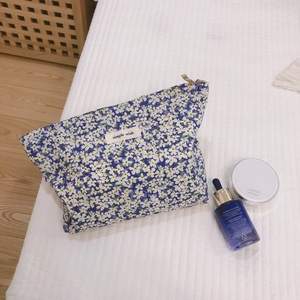 Floral cotton makeup bag with blue patterns and a top zipper for everyday cosmetic storage