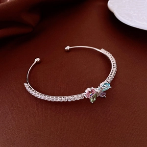 Détail d'un bracelet manchette papillon en argent avec zircons colorés sur soie