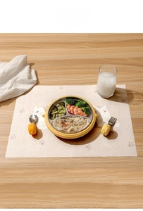 Close-up of children's disposable placemat with partitioned stainless steel tray and utensils