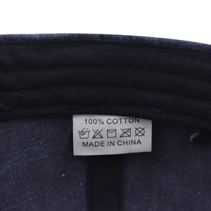 Détail macro de l'étiquette 100% coton et des coutures intérieures de la casquette