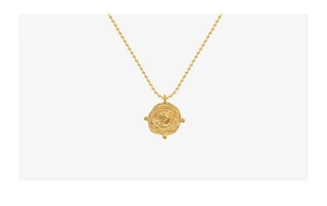 Detailed close-up of vintage embossed gold disc pendant on a classic bead chain