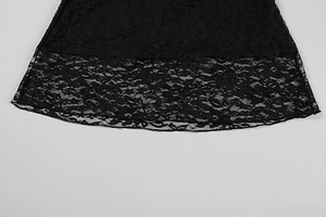 Detailed macro view of the intricate floral lace hem on a slim-fit black evening dress