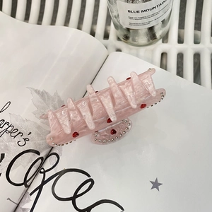 Dettaglio molletta per capelli rosa con cuore e strass su finitura marmorizzata