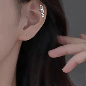 Macro shot of titanium star-shaped ear crawler with sparkling cubic zirconia on model