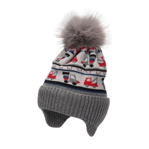 Close-up of knit texture on boys gray car pattern winter hat with faux fur pom pom