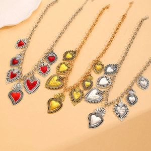 Detailed shot of retro sacred heart pendants in red, gold, and silver on metal chains
