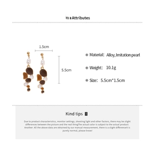 Detail view of pearl and enamel geometric earrings showing 5.5cm by 1.5cm dimensions