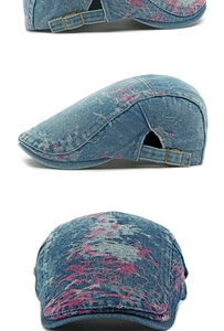 Detail view of denim flat cap showing pink vintage graffiti print and adjustable buckle