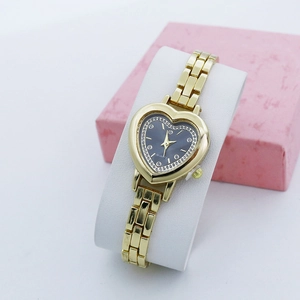 Detail of heart-shaped gold quartz watch with blue crystal dial on display stand