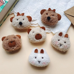 Detailed view of handmade plush animal head brooches including brown bears and white rabbits