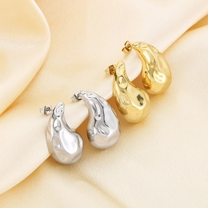 Modern gold and silver drop earrings with organic hammered texture on silk background