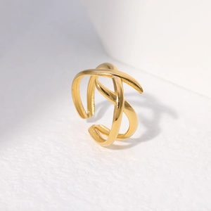 Macro detail of golden irregular geometric open ring on a textured white surface
