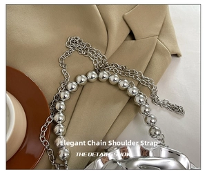 Close-up of silver metal chain strap with large mirror beads and lobster clasp detail