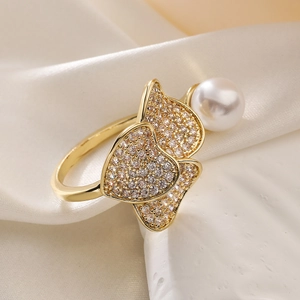 Detail of gold plated heart ring with shimmering pavé zircons and a round pearl accent