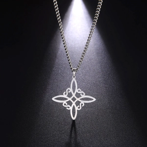 Macro shot of silver Celtic knot pendant with intricate hollow design on dark texture