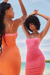 Detail von Spitzenbesatz und Rippstoff an orangefarbenen und rosa Sommerurlaubskleidern