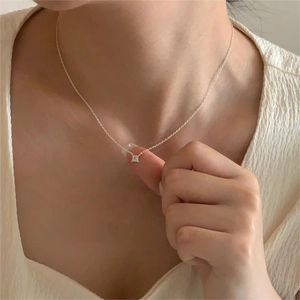 Close-up of a square-cut zircon pendant on a silver S925 chain worn by a model