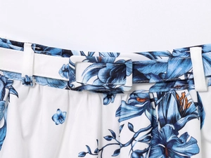 Detailed view of the fabric belt with rectangular buckle and blue floral print on white