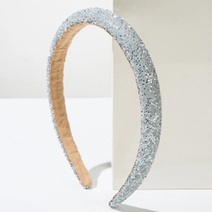 Elegant silver glitter padded headband on a white geometric stand with minimalist style