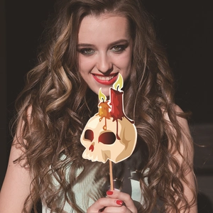 Woman holding a skull candle prop from a 20-piece Halloween photo booth set decoration