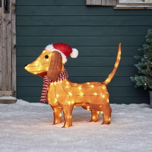Close-up of lighted metal mesh dachshund garden stake with warm white LED lights in snow