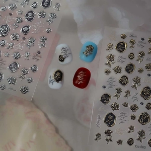 Macro detail of 3D embossed rose nail stickers with metallic gold and silver finish