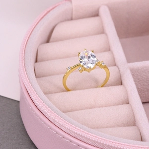 Macro shot of an elegant gold ring with an oval gemstone in a pink velvet jewelry box