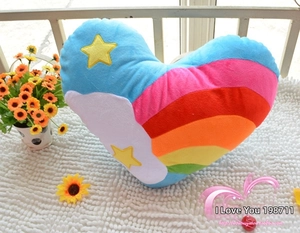 Detailed macro view of heart-shaped rainbow plush pillow with star embroidery on soft rug