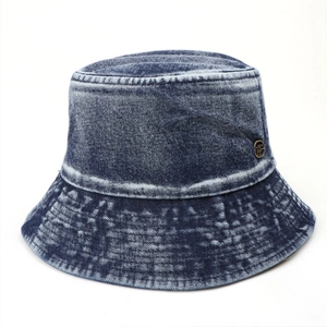 Detail of vintage washed denim bucket hat with a round metallic logo emblem