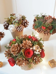 Close-up of a festive Christmas centerpiece with pine cones berries and burlap base