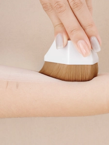 Detailed view of dense bristles applying liquid foundation smoothly on the skin