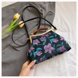 Detail of black cheongsam handbag with purple floral embroidery and wooden handle